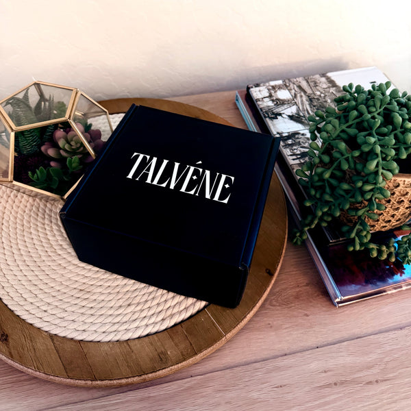 Black box with Talvéne branding on a wooden surface with decorative elements.